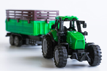 Toy tractor with a trailer on a white background. The concept of educational toys and acquaintance with professions. Selective focusing