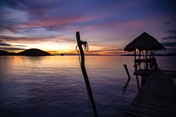 Sunset over wooden beach bar in sea and hut on pier in koh Mak island, Trat, Thailand