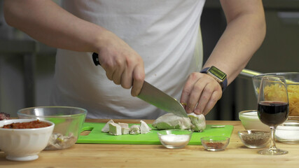 Cropped shot of chef chopping chicken brests in restaurant
