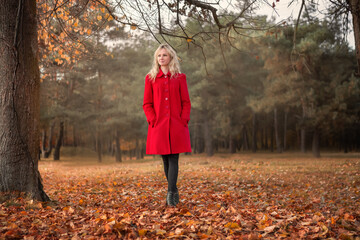 beautiful young girl in a red coat on a walk
