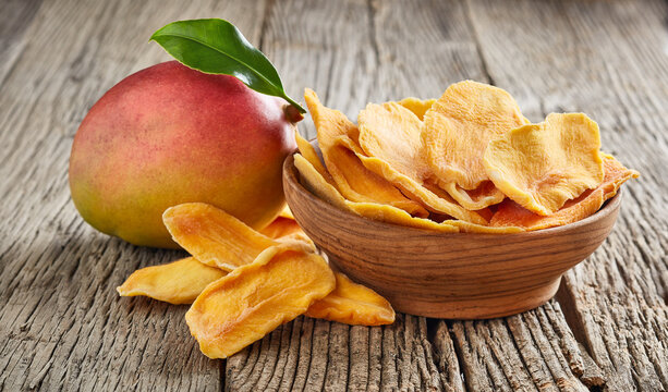 Mango slices on wooden background