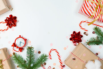 Flat lay christmas composition. Christmas gifts, pine branches, toys, candy canes on a white background. The apartment was lying, top view.