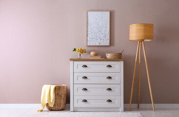 Elegant room interior with stylish chest of drawers and floor lamp