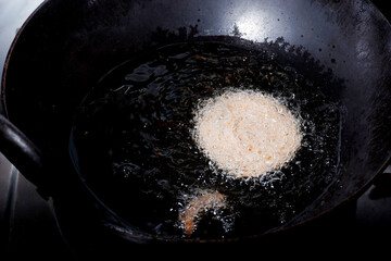 Homemade Preparation of Indian Traditional Snack Chakli consumed during diwali festival, a spiral shaped crisp deep fried snack, It is known as Chakali, Murkoo, Muruku and Murukku.
