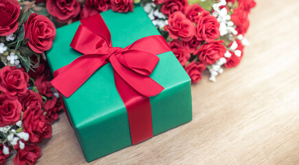 Gift box and Christmas decorations background, flat lay. Space for text. Beautiful Christmas present boxes on wood floor with rose and colorful flower. Happy new year concept. lovely valentine's day.