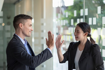 Business man and woman business hi five bump hand together for team work, diversity caucasian asd...