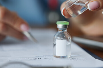 Close-up female doctors hand holding clear glass