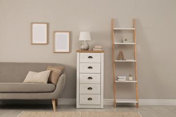 Modern room interior with chest of drawers near light wall