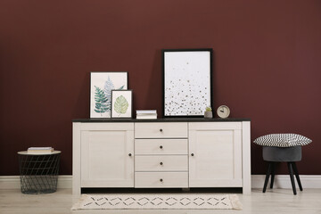 Modern room interior with chest of drawers near brown wall