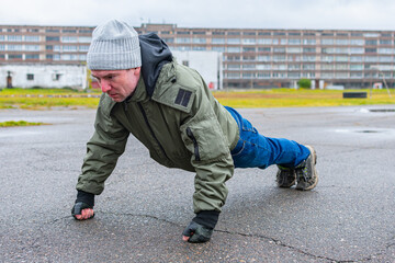 Autumn fitness on the street in the form of push-ups on the chest