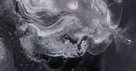 Black white paints in motion abstract background, close-up. Black white ink art. Backdrop of explosion dynamic shiny paints. Texture of silver gray watercolor liquid. Splash of dark ink