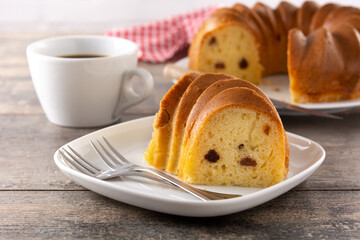Traditional bundt cake piece with raisins on wooden table
