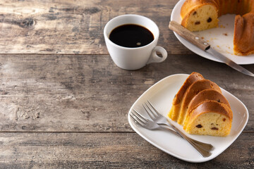 Traditional bundt cake piece with raisins on wooden table
