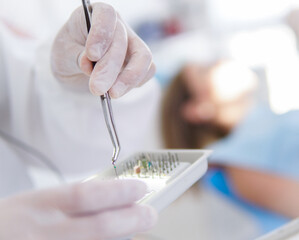 profesional medico odontólogo utilizando herramientas especificas para la labor de dentista con guantes de látex  - obrazy, fototapety, plakaty