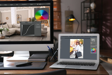 Naklejka premium Retoucher's workplace. Computer and laptop with photo editor applications, graphic tablet on table indoors