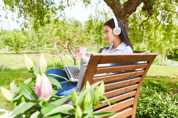 Freelance woman video chat in green garden