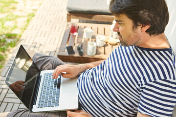 Freelancer works on the laptop on the terrace