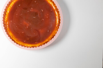 Classic cheesecake with caramel sauce on white plate on gray background. Copy space for text.