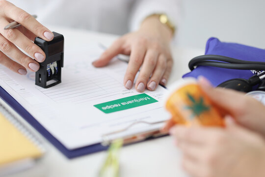 Close-up of practitioner hand giving stample on prescription