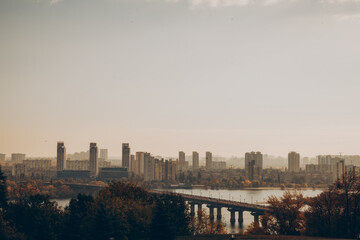 Panorama of the city background, autumn landscape of a modern city, high-rise buildings and a motorway across the river, the seluet of the city