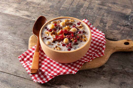 Traditional Turkish Noah's pudding in bowl on wooden table	
