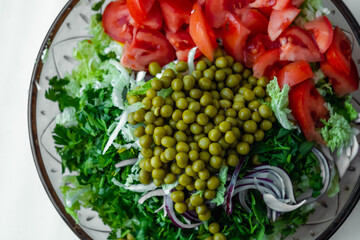 Fresh vegetable salad with Chinese cabbage, tomato, green peas, parsley. Healthy food.