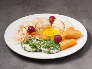 assorted cheese in a restaurant with honey on a white plate