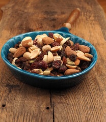 Nut mixture with raisins in a blue bowl