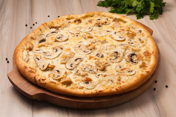pizza with chicken and mushrooms on a wooden board