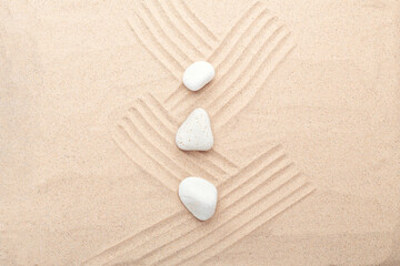 White stones on the sand. Lines drawn on the sand. Top view