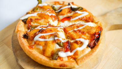 Italian pizza with some tasty topping on it. a studio shot of a delicious food served on the wooden peel.