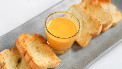 the golden brown toasted bread served with a cup of cheese sauce. a typical of breakfast menu for western.