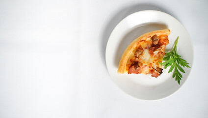 a slice of Italian pizza on a white plate with some tasty topping on it. a studio shot of a delicious food with copy space.