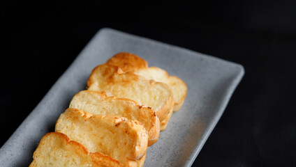 the golden brown toasted bread served on a grey plate isolated on black. a typical of breakfast menu for western.