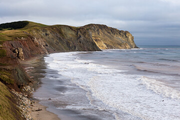 High angle view of the Petite Echouerie beach at the foot of red and grey sandstone cliffs, Havre-aux-Maisons, Magdalen Islands, Quebec, Canada