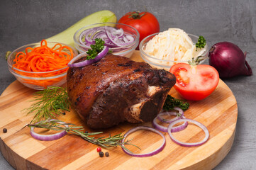 baked pork knuckle with onions, carrots and cabbage