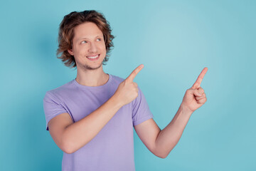 Photo of young man good mood look indicate fingers empty space promotion offer sale isolated on teal color background