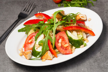 salad with vegetables, grilled cheese and pine nuts