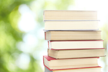 Stack of books on blurred background, space for text. Bokeh effect