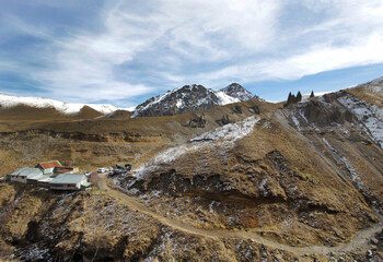 Dirt road to the spring against the background of brown mountains and sharp unique rocks