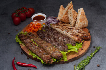 assorted lula kebab: pork, lamb, chicken on a wooden board