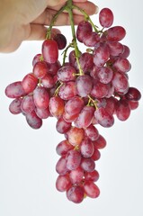 bunch of fresh seedless red grapes isolated on white background.