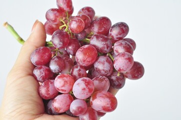 bunch of fresh seedless red grapes isolated on white background.