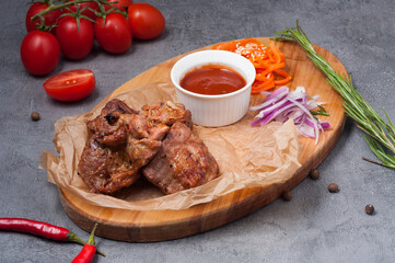 pork neck kebab with tomato sauce on a wooden board