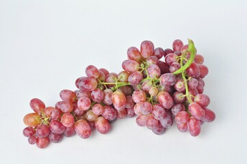 bunch of fresh seedless red grapes isolated on white background.