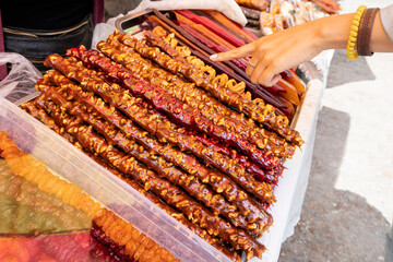 Woman chooses a churchkhela at a local Georgian or Armenian market. This is a traditional dessert...