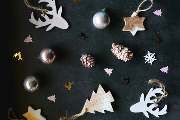 Obraz na płótnie Canvas Various Christmas ornaments and colorful sequins on dark background. Flat lay.