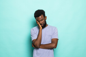 Young sad african american man isolated on green background. People lifestyle concept.