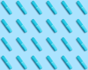Many tampons on light blue background, flat lay