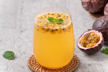 Delicious juicy passion fruit with sparkling juice on gray table background.